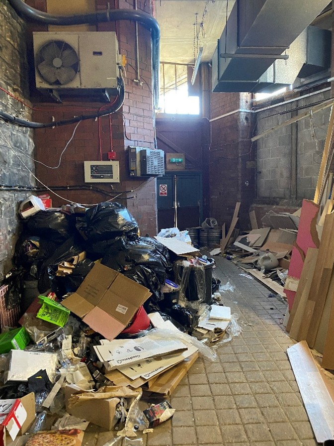 Waste stored on a fire escape route and by the fire alarm panel