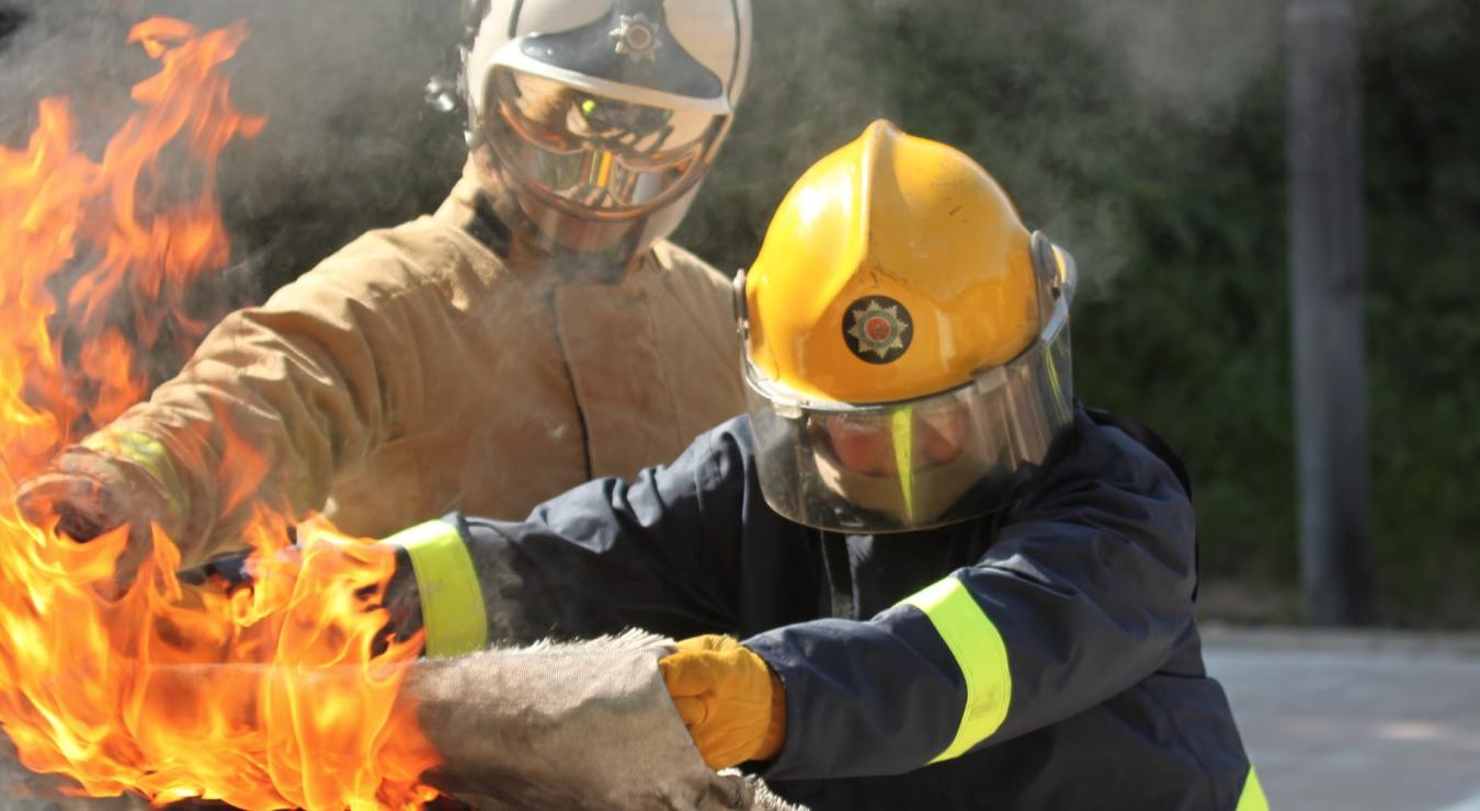 Image of two firefighter tackling a fire