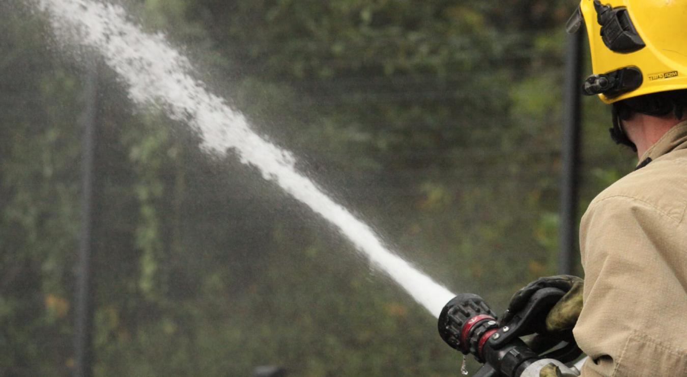 Image of a firefighter using a hose reel