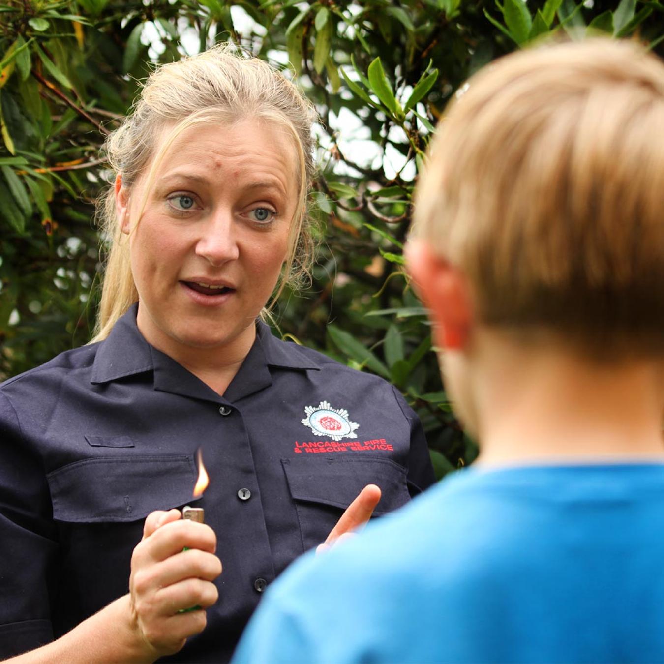 firefighter educating young person about the dangers of fire